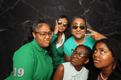 A playful group of guests dressed in green posing for the booth